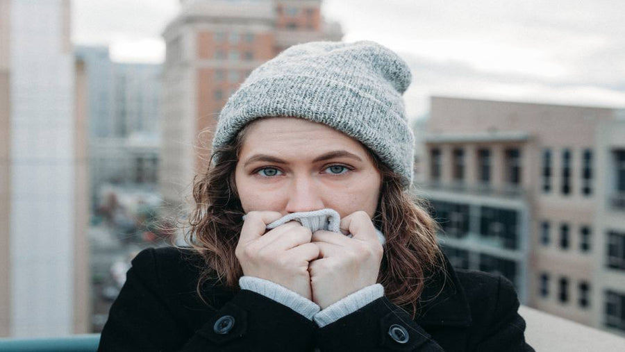 A woman with joint pain outside during the cold weather months